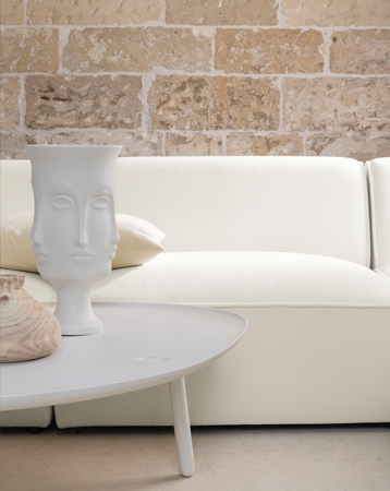 strahlend weißes Sofa vor Steinwand