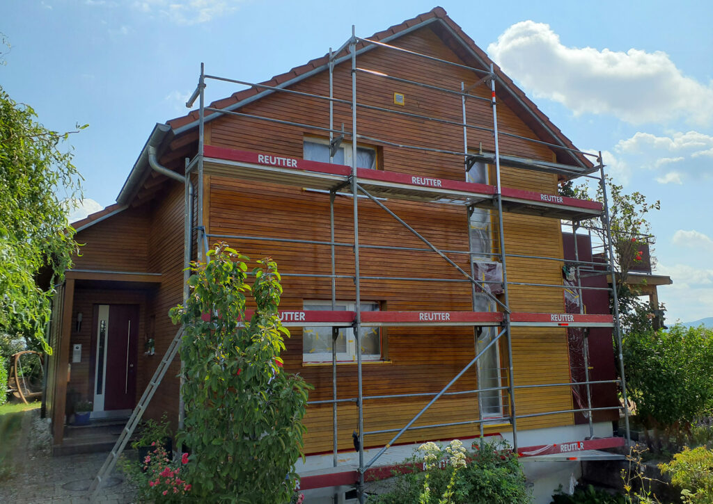 Holzhaus Fassade wird saniert mit Reutter Gerüst davor