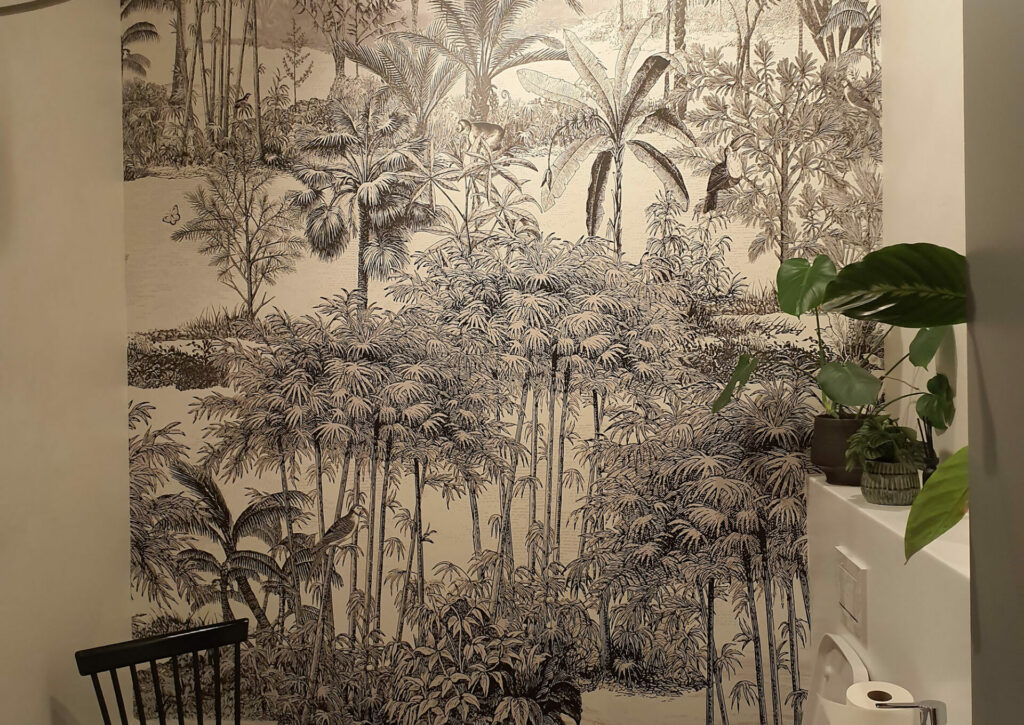 eine schwarz weiße Tapete mit Dschungelmotiv an der Badwand
